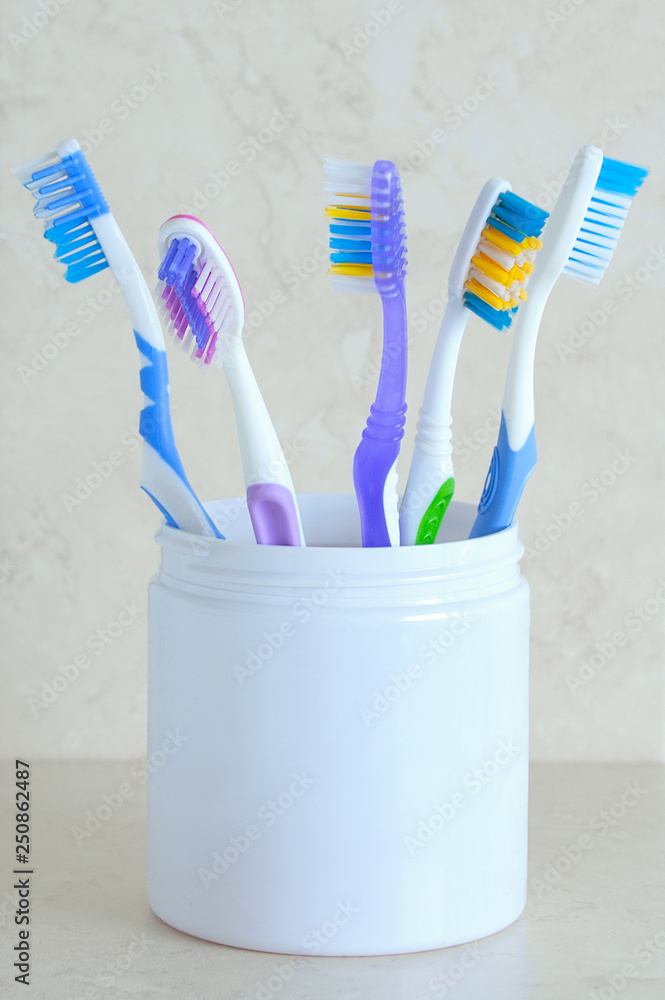 Toothbrushes in white glass. On a marble background. Close-up. Toothbrushes in white glass. On a marble background. Close-up.
