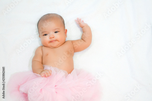 Newborn baby wear pink tutu skirt on white towel background