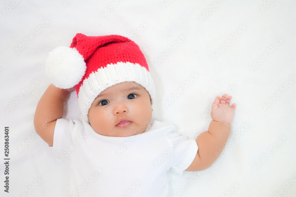 Asian newborn baby wear white dress and red Christmas knitting hat on white towel background. Newborn baby is ready for Christmas. Asian newborn baby wear white dress and red Christmas knitting hat on white towel background. Newborn baby is ready for Christmas.