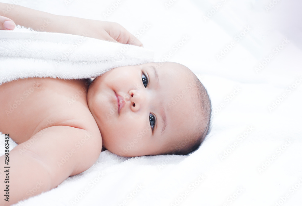 Mother hand wiping newborn baby after shower on white towel background. Asian newborn baby is getting dry after bath time. Mother hand wiping newborn baby after shower on white towel background. Asian newborn baby is getting dry after bath time.