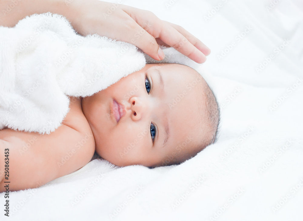 Mother hand wiping newborn baby after shower on white towel background. Asian newborn baby is getting dry after bath time. Mother hand wiping newborn baby after shower on white towel background. Asian newborn baby is getting dry after bath time.