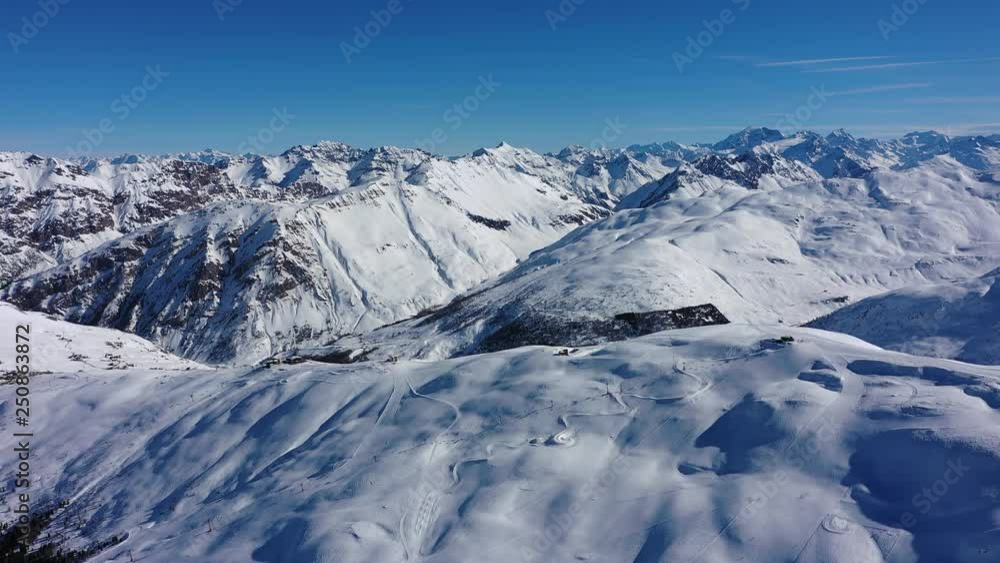 Aerial panoramic view of Alps, landscape panorama of snowy mountain range in winter, sunny day with blue sky - Alps from above, Livigno, Italy, Europe Aerial panoramic view of Alps, landscape panorama of snowy mountain range in winter, sunny day with blue sky - Alps from above, Livigno, Italy, Europe