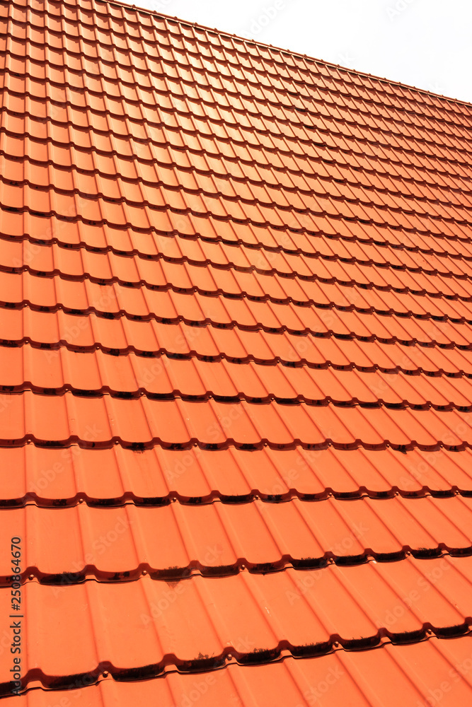 Orange concrete roof tiles on a residential home. Roof tiles background texture. Orange concrete roof tiles on a residential home. Roof tiles background texture.
