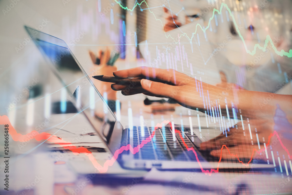 Hands typing on laptop. Business and Financial concept. Double exposure of stock market charts. Hands typing on laptop. Business and Financial concept. Double exposure of stock market charts.