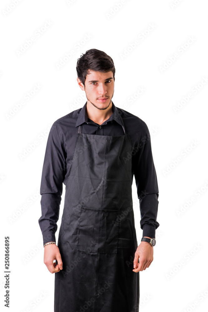 Fototapeta premium Young chef or waiter posing, wearing black apron and shirt isolated on white background