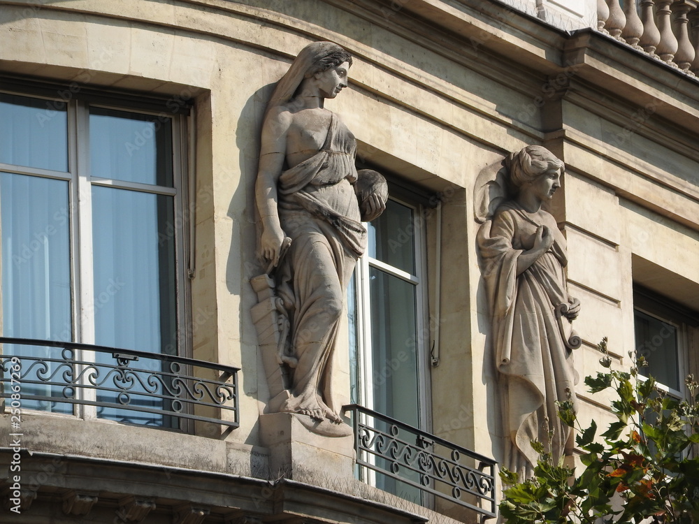 Obraz premium Stone figures on the facade of a house in Paris.