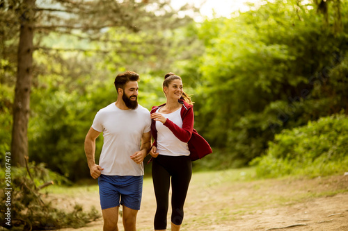 Healthy fit and sportive couple running in nature