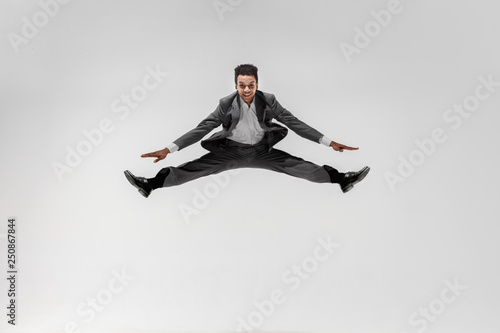 Happy businessman dancing in motion isolated on white studio background. Flexibility and grace in business. Human emotions concept. Office, success, professional, happiness, expression concepts