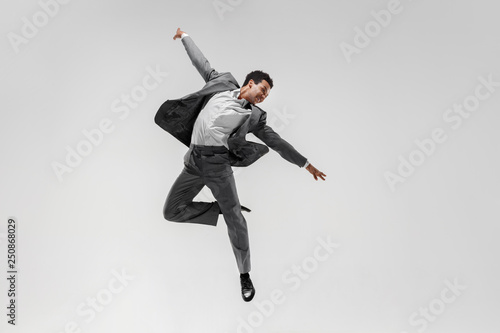 Happy businessman dancing in motion isolated on white studio background. Flexibility and grace in business. Human emotions concept. Office, success, professional, happiness, expression concepts