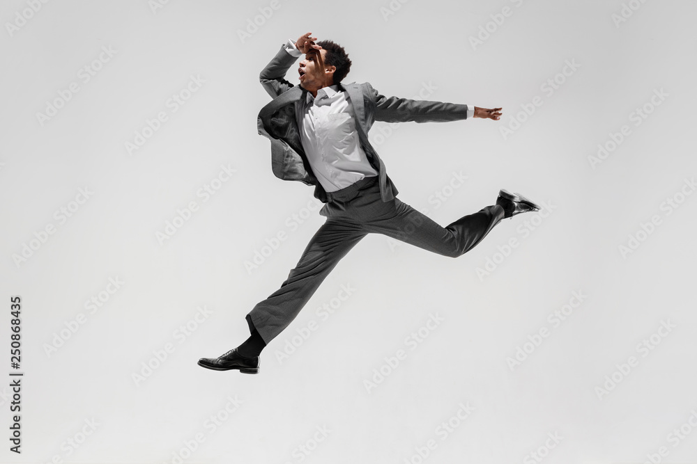 Happy businessman dancing in motion isolated on white studio background. Flexibility and grace in business. Human emotions concept. Office, success, professional, happiness, expression concepts
