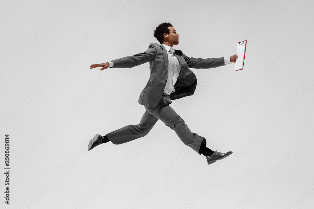 Happy businessman dancing in motion isolated on white studio background. Flexibility and grace in business. Human emotions concept. Office, success, professional, happiness, expression concepts