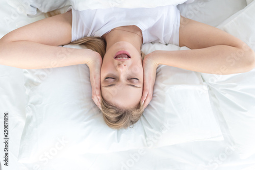 attraactive girl singing a song while resting in the bed, top view photo