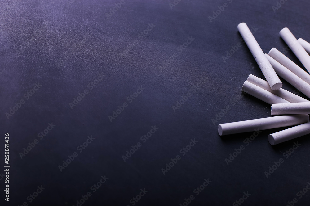 Crayons lie on a black chalkboard, copy space. The concept of school, education and childhood. Crayons lie on a black chalkboard, copy space. The concept of school, education and childhood.