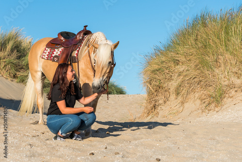girl with horse posing in the dunes
