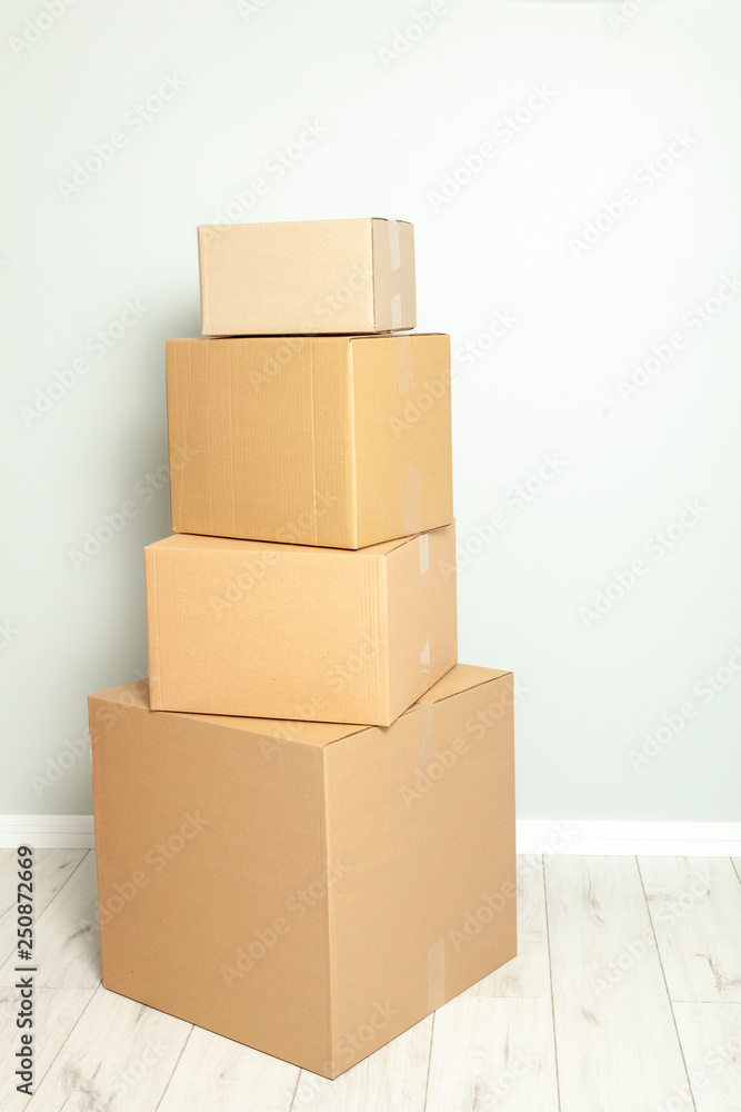 Obraz premium Day moving. Delivery of goods, shopping. Cardboard boxes on gray wall background