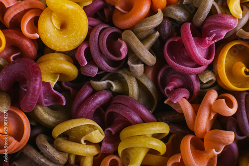 Multi-colored macaroni of an unusual form with natural vegetable dyes. Background closeup.