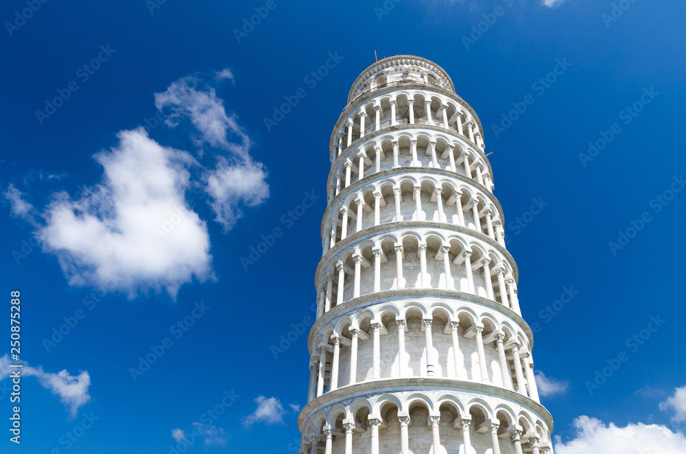 Leaning Tower Torre di Pisa on Piazza del Miracoli square, blue sky with white clouds background in beautyful sunny day, view from below close-up isolated copy space, Tuscany, Italy