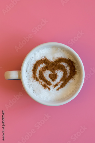 Heart Shape Coffee Cup Concept isolated on pink background. love cup , heart drawing on latte art coffee. vertical photo