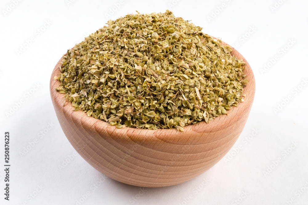 oregano herb in wooden bowl isolated on white background. oregano herb in wooden bowl isolated on white background.