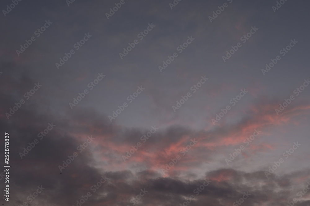 Evening sky during february with red purple violet sun light and clouds