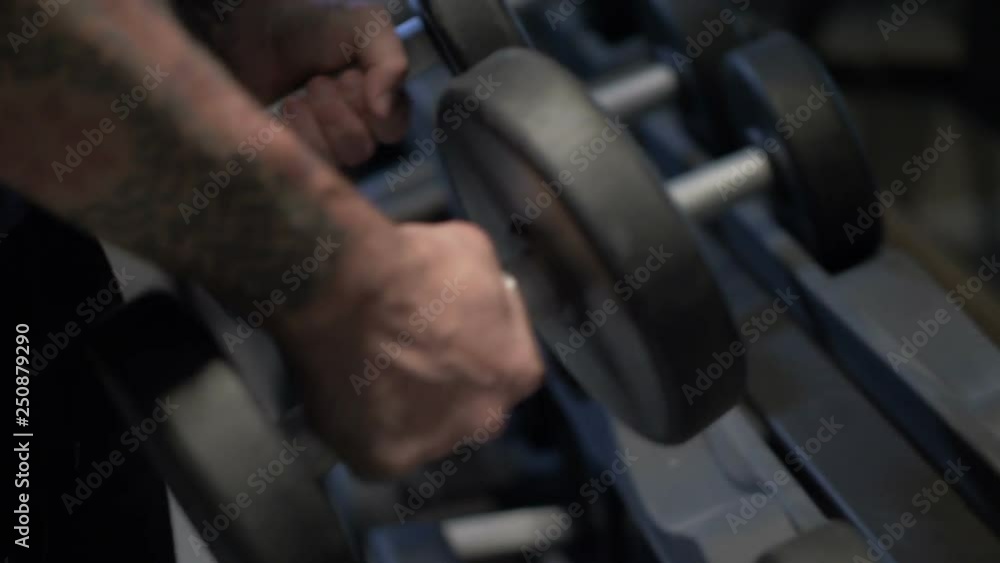 Close-up of male hands taking the dumbbell Close-up of male hands taking the dumbbell