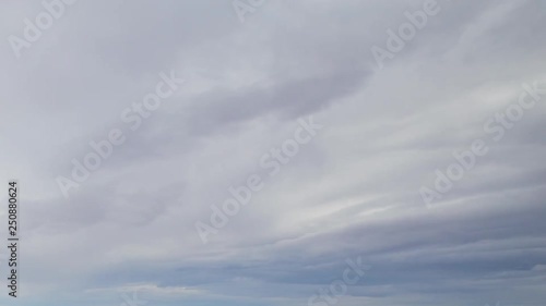 Russia, time lapse. Formation and rapid movement of white clouds of different shapes in the blue sky in late spring at sunset. 