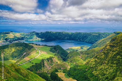 Lake in wide volcanic caldera, called Lagoa Azul in Portuguese, surrounded by green mountains of Sete Cidades, located on Sao Miguel island of Azores, Portugal.