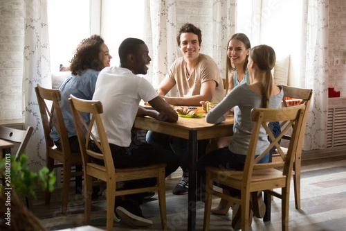 Multiracial laughing friends having fun together, talking in cafe © fizkes