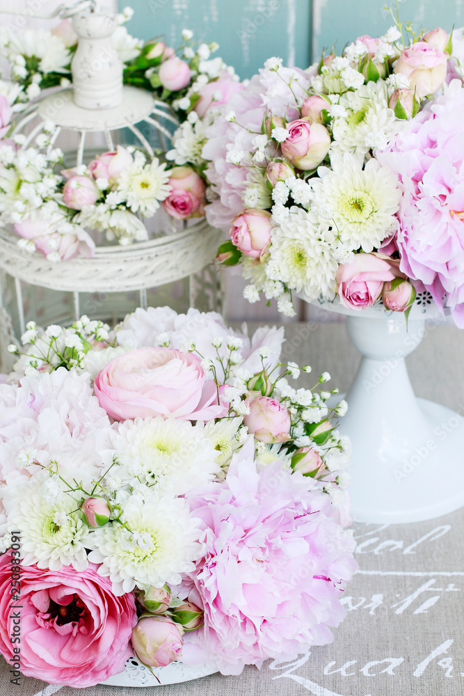 Floral arrangement with pink peonies, tiny roses, chrysanthemums and gypsophila paniculata twigs.