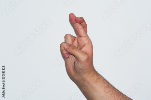 hand isolated on white background with fingers crossed, wishing luck
