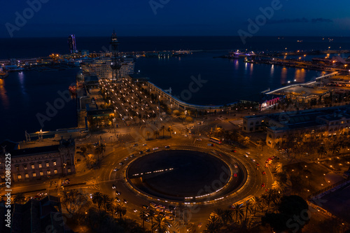 Night aerial photo of port vellof Barcelona and road with car traffic
