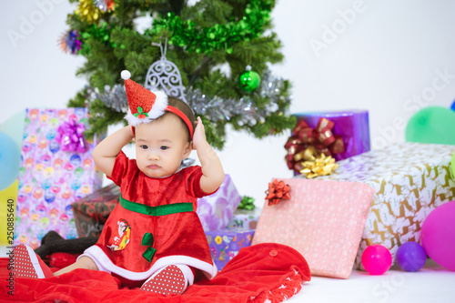 Baby in a christmas dress sitting