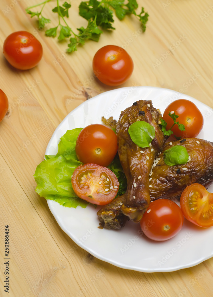 drumstick chicken in soy sauce with cherry tomatoes and sesame in on wooden drumstick chicken in soy sauce with cherry tomatoes and sesame in on wooden