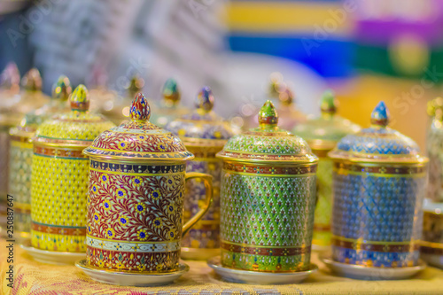 Beautiful traditional Benjarong, Thai five-colored porcelain ceramic cups. Benjarong Porcelain mugs for sale in the flea market, Thailand. photo