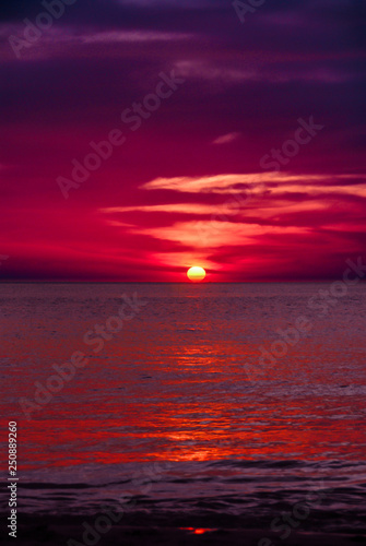 Blood red and dark purple sunset of sun sets over horizon Adaman Sea