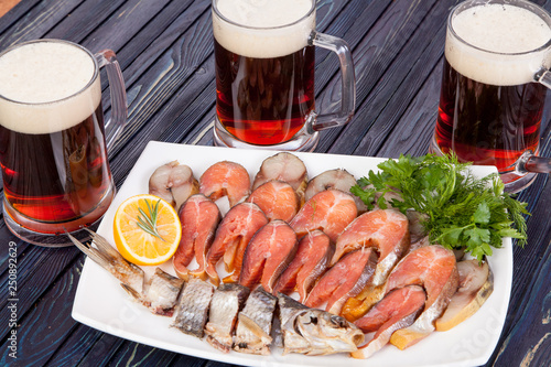 appetizer for beer from dried fish, cheese sticks, smoked onion cheese and loafs with beer on the table for use in design