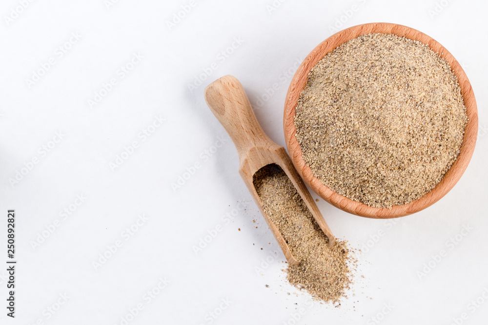ground white pepper in wooden bowl and scoop isolated on white background with copy space added. top view ground white pepper in wooden bowl and scoop isolated on white background with copy space added. top view