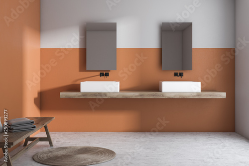 Orange and white bathroom interior, double sink