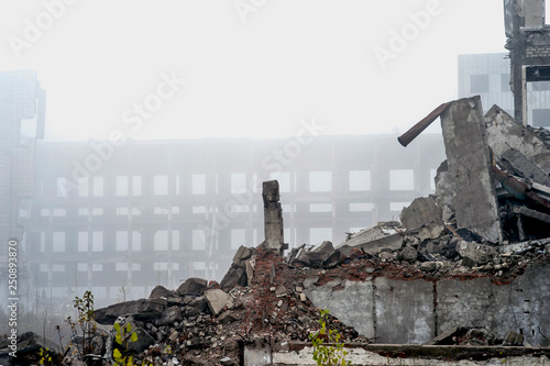 Tablou pe pânză The remains of a large destroyed building with concrete pilings and scattered bricks with rebar in the foreground