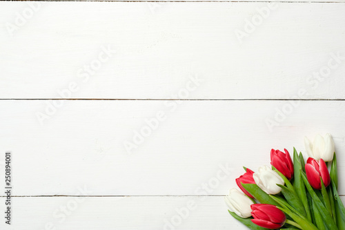 Photography Bouquet of tulips at right corner on white wooden background