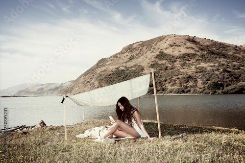 Woman with smart phone on remote beach  photo