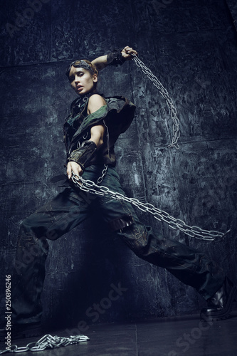 Young woman in brutal futuristic clothes on background 