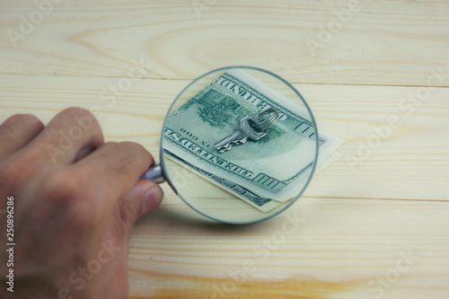 magnifying glass and key with money
