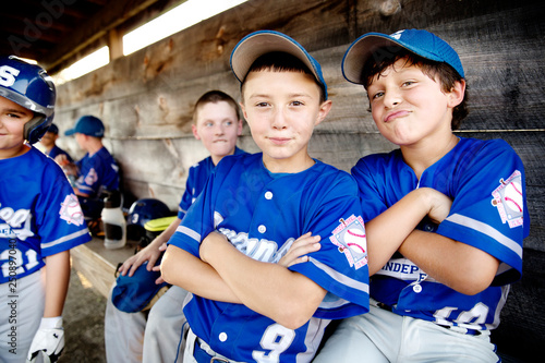 Little league players (8-9, 10-11) goofing around in dugout 