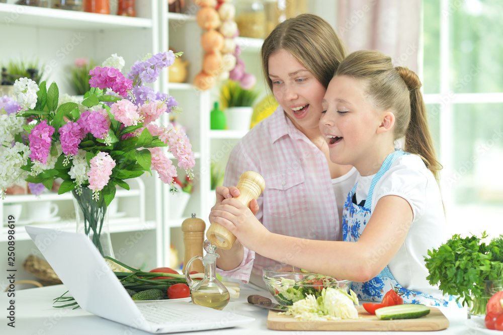 Two girls having fun while preparing fresh salad Two girls having fun while preparing fresh salad