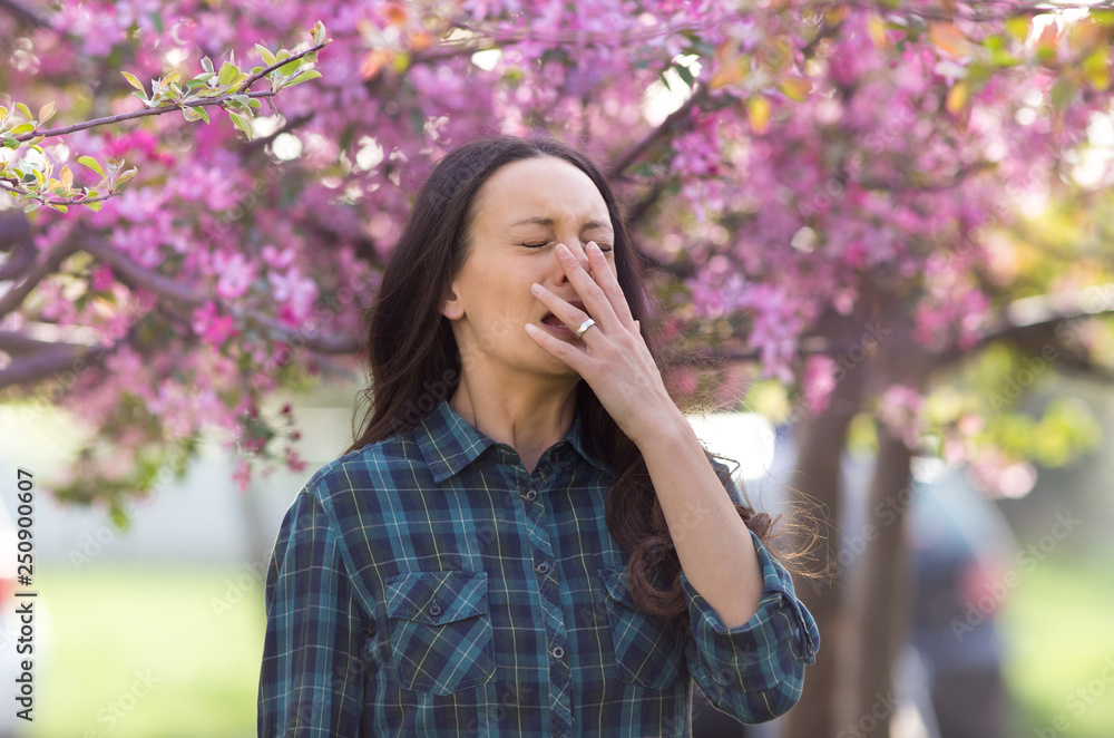 Woman sneezing because of spring pollen allergy Woman sneezing because of spring pollen allergy