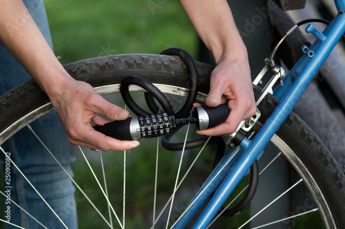 Woman locking bicycle with combination lock