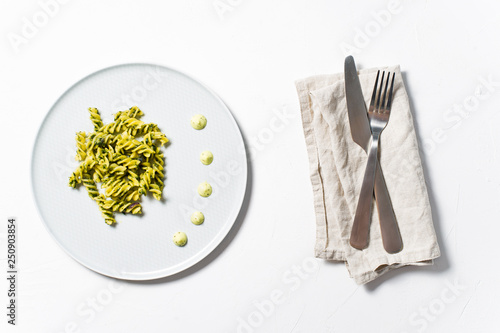 Gluten-free pasta with spinach. Diet dish. Minimalism. White background, top view