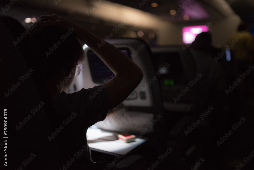 Man reading and watching films during an intercontinental night flight Man reading and watching films during an intercontinental night flight
