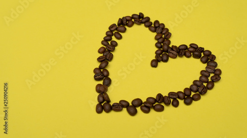 Heart of coffee beans on the right on a yellow background